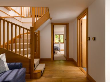 A hallway with stairs and doors at Hoppers Barn in Pancrasweek near Holsworthy