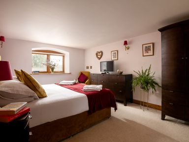 A bedroom with a bed and dresser at Hoppers Barn Pancrasweek near Holsworthy