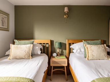 A bedroom with twin beds and a bedside table at Hoppers Barn Pancrasweek near Holsworthy