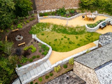 A garden with pathways and a fire pit at Hoppers Barn in Pancrasweek near Holsworthy