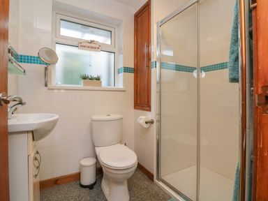 A bathroom with a toilet sink shower and a small window at Hillsview in Combe Martin