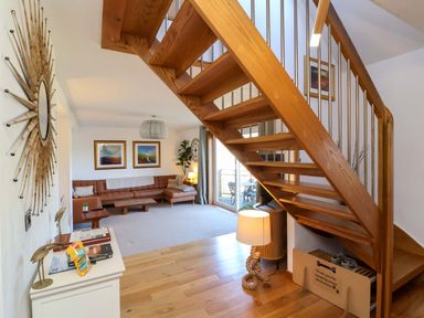 A living room with a staircase and sofa at Hillsview in Combe Martin