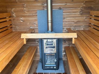 A sauna with wooden benches and a stove at Hillsview in Combe Martin