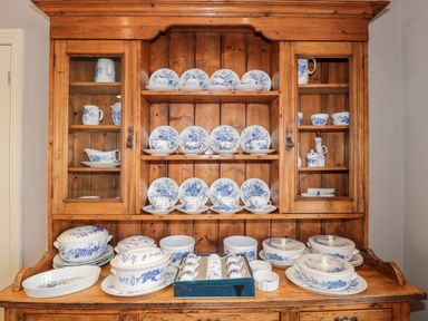 A wooden dresser with blue and white china dishes and cups displayed at The Pound in Porlock