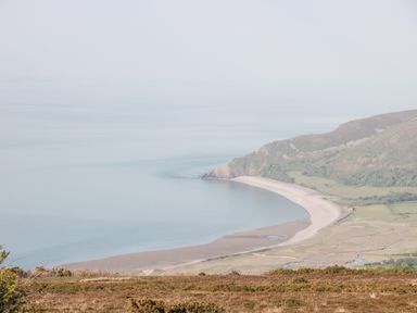 A coastal landscape with a curved beach and hills at The Pound in Porlock