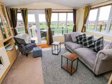 A living room with a sofa and armchair at Reef Retreat in Little Haven