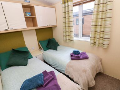 A bedroom with twin beds and towels at Reef Retreat in Little Haven