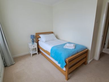 A bedroom with a single bed and bedside table at 30 Long Shepherds Drive, Newton near The Mumbles