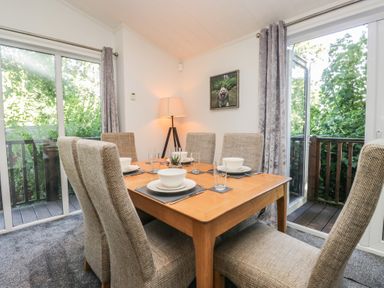 A dining room with a table set for dinner at Treetops, Beech Hill 13, Fallbarrow Park near Bowness-On-Windermere