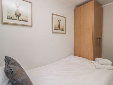 A bedroom with a bed and wardrobe at Treetops Beech Hill 13 ,Fallbarrow Park near Bowness-On-Windermere