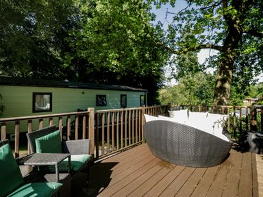 An outdoor area with a sofa, chair, and table at Treetops Beech Hill 13, Fallbarrow Park near Bowness-On-Windermere
