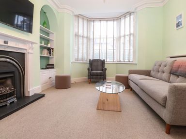 A living room with a sofa armchair coffee table and fireplace at Blencathra in Keswick