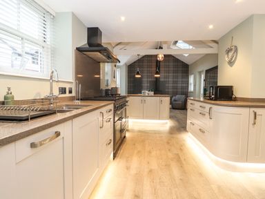 A kitchen with white cabinets a countertop stove and a sink at Blencathra in Keswick