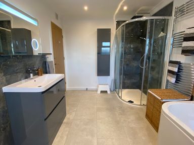 A bathroom with a sink cabinet mirror shower enclosure bathtub laundry basket and towel rail at Ashlea in Launceston