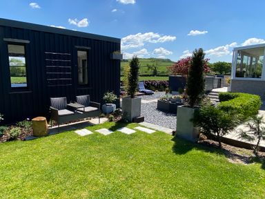 An outdoor garden area with lawn chairs plants and a lawn at Ashlea in Launceston