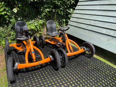Two orange go-karts on a mat in a garden at Ashlea Launceston