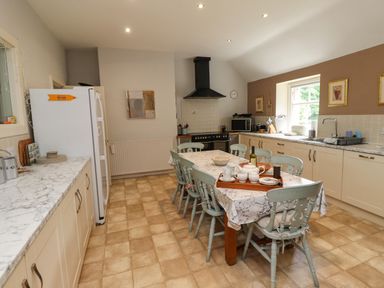 A kitchen with a marble countertop dining table and light blue chairs at Craster Tower Penthouse in Craster