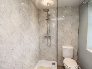A bathroom with a shower area and a toilet at No2 Budle Bay Cottage in Bamburgh