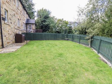 A garden with green grass and a fence at Crispin in Lucker