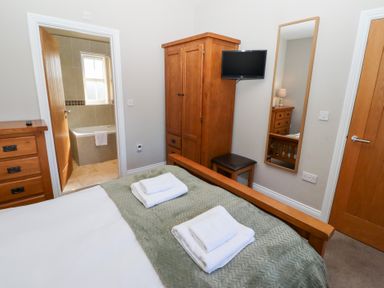 A bedroom with a bed and wardrobe at Pippin Lucker