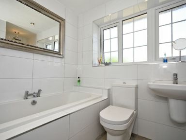 A bathroom with a bathtub a toilet a sink and a large mirror at Inveray in Seahouses