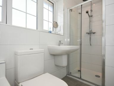 A bathroom with a toilet sink and glass shower enclosure at Inveray in Seahouses