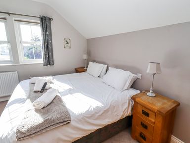 A bedroom with a bed and bedside table at Bramley in Lucker