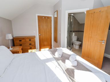 A bedroom with a bed and adjacent bathroom at Bramley in Lucker