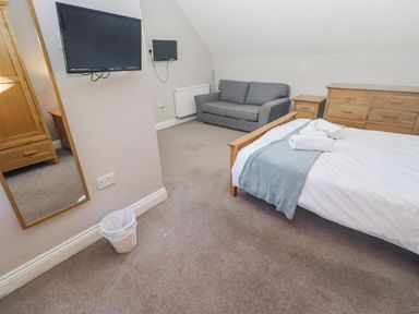 A bedroom with a bed and a couch at Bramley in Lucker