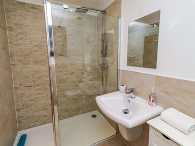 A bathroom featuring a shower and sink at Farne Cottage in Beadnell