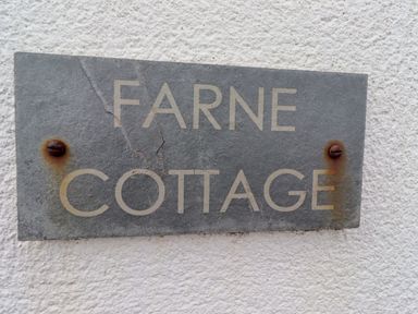 A sign with the words Farne Cottage