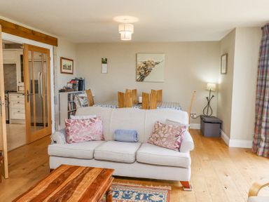 A living room with a sofa and dining table with chairs at The Mustard Pot in Acklington