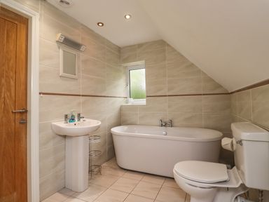 A bathroom with a freestanding bathtub pedestal sink and toilet at Quarry Haven in Bamburgh