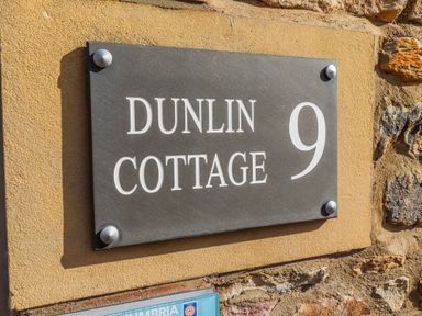 Nameplate displaying Dunlin Cottage 9 on a wall