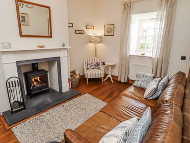 A living room with a fireplace and a sofa at No9 Budle Sands in Bamburgh