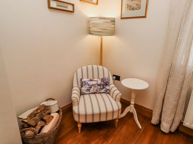 A snug with an armchair and side table at No9 Budle Sands in Bamburgh