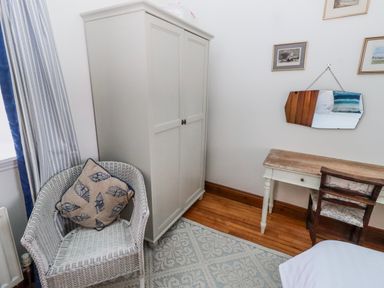 A bedroom with a wardrobe, desk, and chair at No9 Budle Sands in Bamburgh