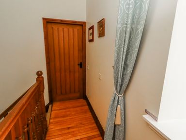 A hallway with a door and a curtain at No9 Budle Sands in Bamburgh