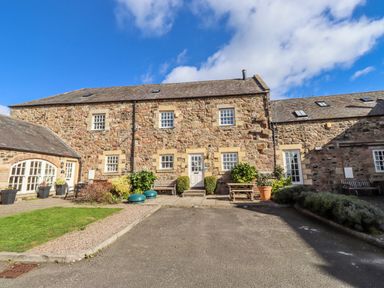 A stone building with windows and a door at No9 Budle Sands in Bamburgh
