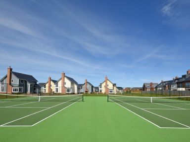 Two tennis courts with nets and houses in the background at Spindrifter in Beadnell