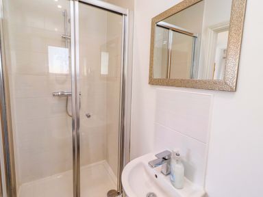 A bathroom with a shower and sink at Spindrifter in Beadnell
