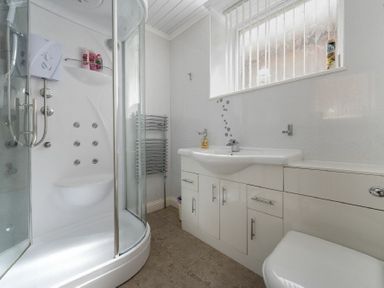 A bathroom with a shower cabin sink with cabinet and toilet at Lobster Lodge in Seahouses