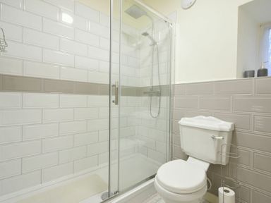 A bathroom with a shower enclosure and a toilet at West End Cottage in Embleton