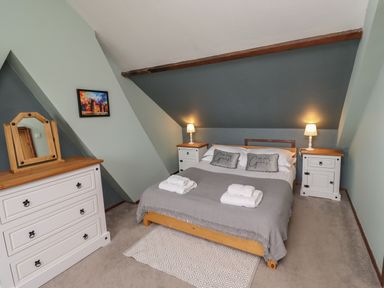 A bedroom with a double bed and bedside tables with lamps at Number Seventeen in Amble