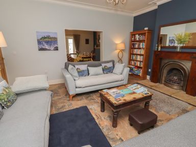 A living room with a sofa, coffee table, and bookcase at Number Seventeen Amble