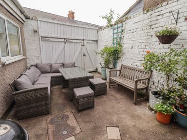 An outdoor patio area with seating and plants at Number Seventeen Amble