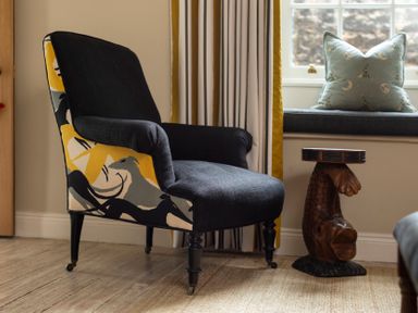 A living room with an armchair and a side table at Sandpiper (Alnmouth)