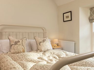 A bedroom with a bed and decorative pillows at Sandpiper in Alnmouth