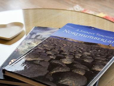 A close up of a table with two books and a heart shaped dish on it at Portside in Seahouses