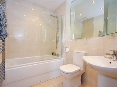 A bathroom with a bathtub shower toilet and sink at Portside in Seahouses